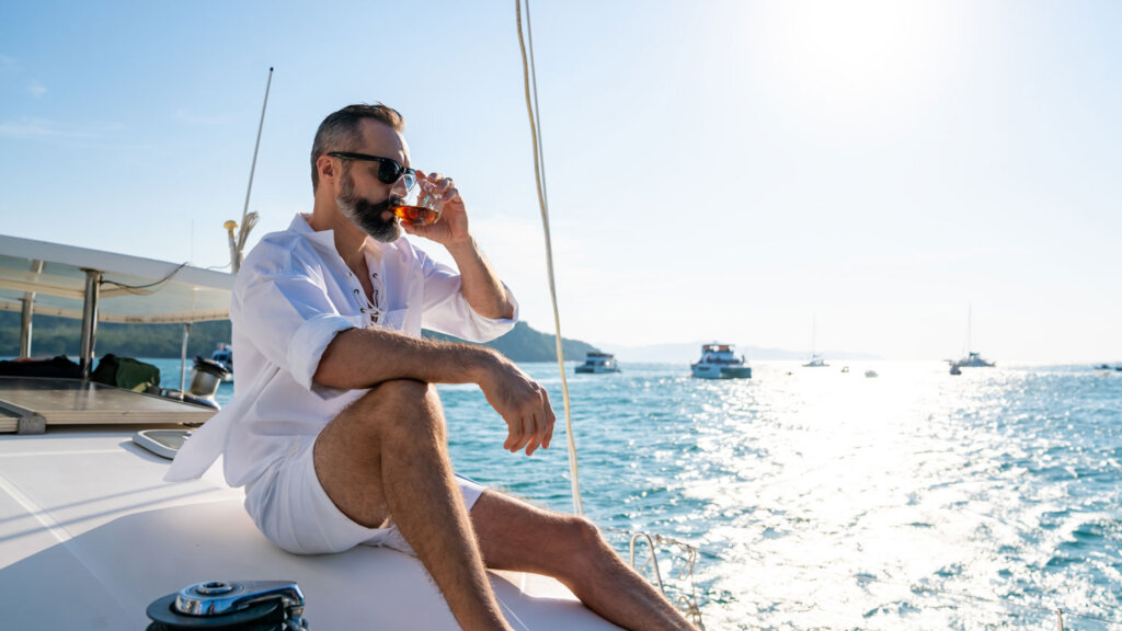 Luxury travel advisor relaxing on a yacht after using AI tools to build a travel itinerary for his clients.