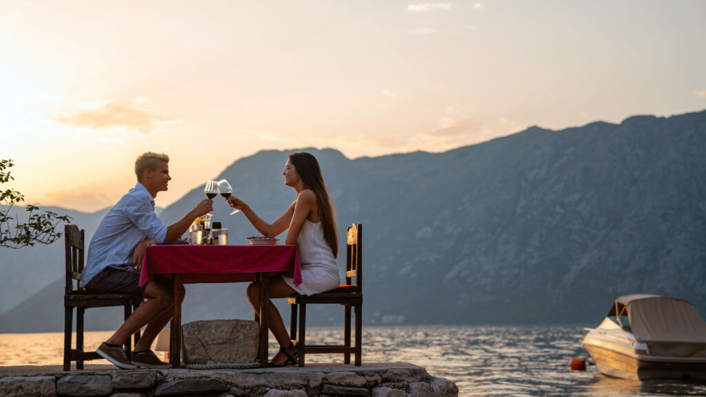 Couple at a romantic waterfront dinner that their luxury travel advisor planned with AI workflow tools.